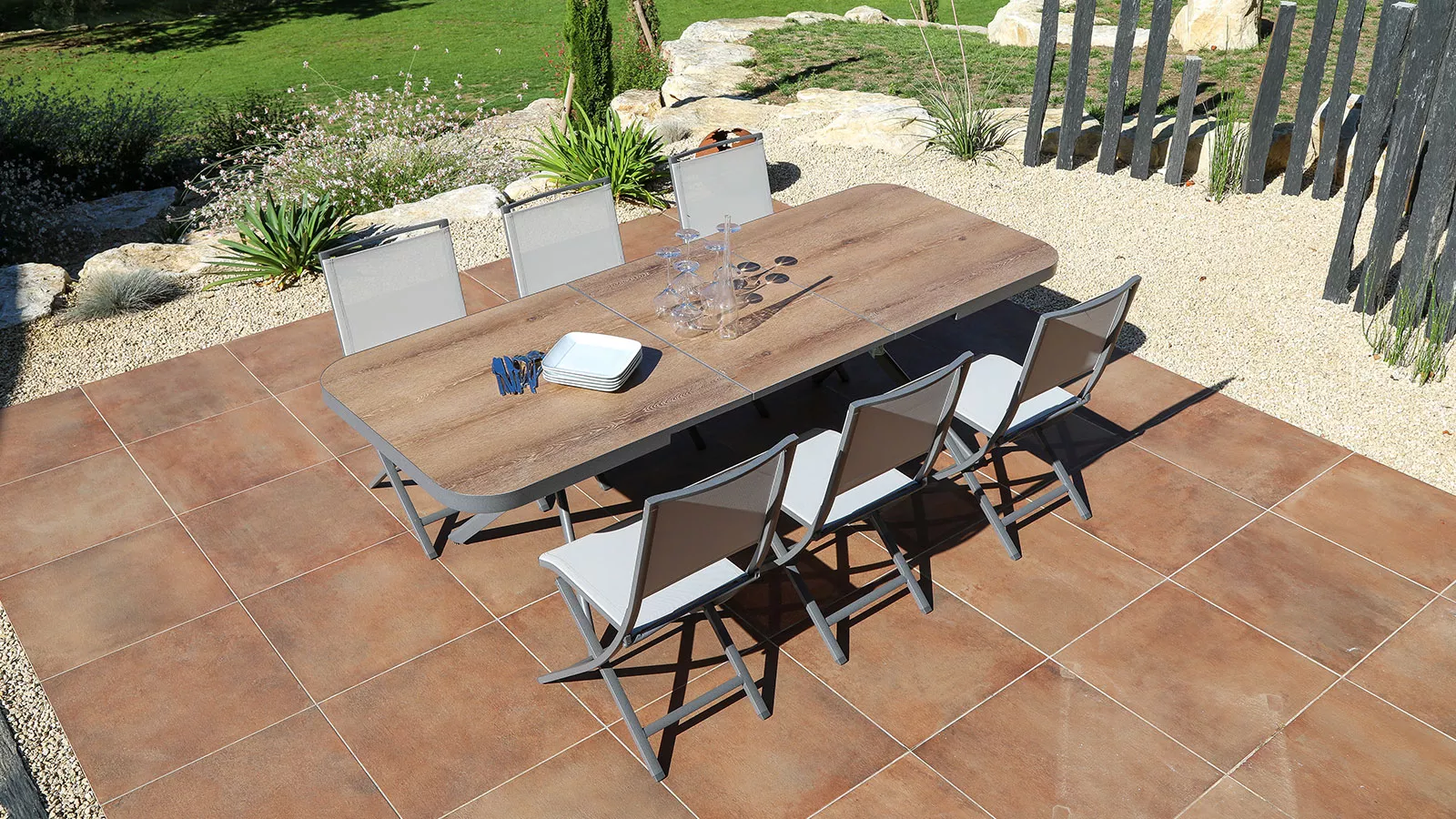 Cette magnifique photo met en avant une Table en aluminium Tromzo extensible à ouverture automatique synchronisée et allonge auto élévatrice avec des chaises en Aluminium tout autour de la table